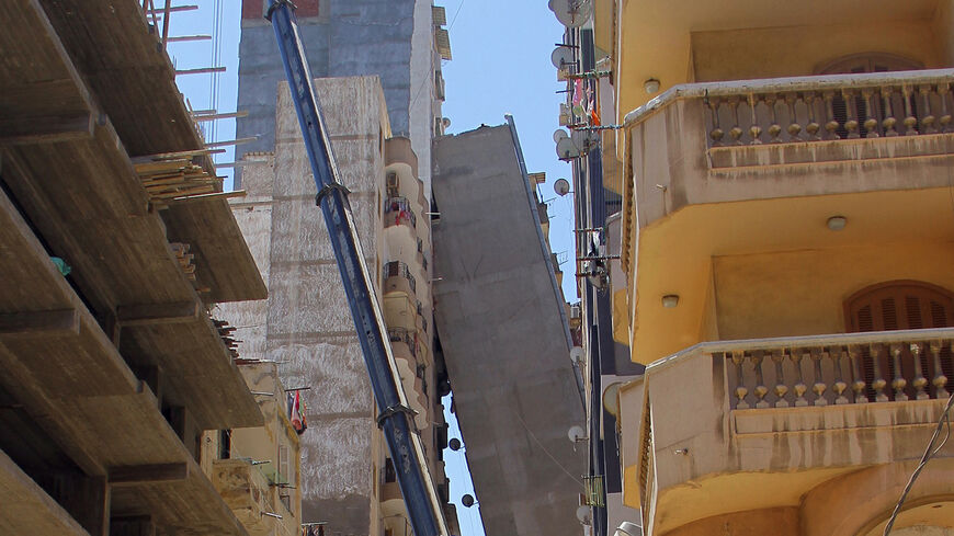 A picture taken on June 1, 2017, shows a general scene of a high-rise residential building toppling over as it leans on another tall building in a central neighborhood in Alexandria, Egypt.